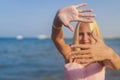 teenage girl blonde with glasses to keep her hands in the sand by the sea Royalty Free Stock Photo