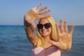 teenage girl blonde with glasses to keep her hands in the sand by the sea Royalty Free Stock Photo