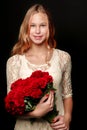 A teenage girl with a bouquet of flowers, on a black background. Royalty Free Stock Photo
