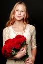 A teenage girl with a bouquet of flowers, on a black background. Royalty Free Stock Photo