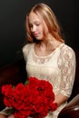 A teenage girl with a bouquet of flowers, on a black background. Royalty Free Stock Photo