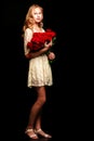 A teenage girl with a bouquet of flowers, on a black background. Royalty Free Stock Photo