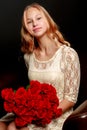 A teenage girl with a bouquet of flowers, on a black background. Royalty Free Stock Photo