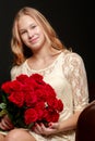 A teenage girl with a bouquet of flowers, on a black background. Royalty Free Stock Photo