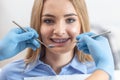 Teenage girl with braces smiles as the dentist checks her teeth