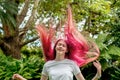 Teenage girl with bright raspberry pink ombre long coloreed hair. Hair up flying in the air. Express yourself