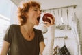 teenage girl with broken arm in cast in kitchen sitting on countertop eating apple