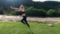 Teenage girl cartwheeling on mountain meadow