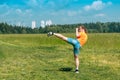 Teenage girl in casual clothes training karate kata outdoors, performs the uro mawashi geri hook kick Royalty Free Stock Photo