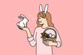Teenage girl celebrating easter holds decorated eggs in basket and small rabbit. Royalty Free Stock Photo