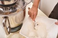 A teenage girl cooks a homemade cake in the kitchen. Mixes the ingredients for the cake in an electric mixer. The hand