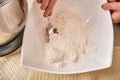 A teenage girl cooks a homemade cake in the kitchen. Mixes the ingredients for the cake in an electric mixer. The hand