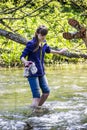 Teenage girl cross the forest river Royalty Free Stock Photo