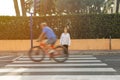 teenage girl crosses the road at a green light and rides a cyclist breaks the rules and rides Royalty Free Stock Photo