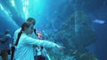 Teenage girl with Dad admire the marine life in the glass tunnel of the Aquarium in Dubai Mall