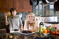 Teenage girl daydreaming in kitchen with brother