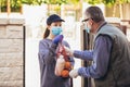 Teenage girl is delivering some groceries to an elderly person, during the epidemic coronovirus Royalty Free Stock Photo