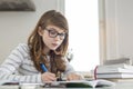 Teenage girl doing homework at table Royalty Free Stock Photo