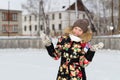 A teenage girl in a down jacket in winter, ice skating, Royalty Free Stock Photo