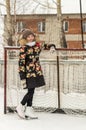 A teenage girl in a down jacket in winter, ice skating, Royalty Free Stock Photo