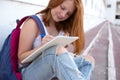 teenage girl draws in the sketchbook while sitting on the steps Royalty Free Stock Photo