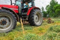 young woman in tractor turning hay in pasture Royalty Free Stock Photo