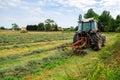 young woman in tractor turning hay in pasture Royalty Free Stock Photo