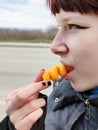 Teenage girl eating corn sticks outdoors close-up Royalty Free Stock Photo