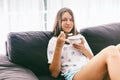 Teenage girl eating brekfast on couch in living room Royalty Free Stock Photo