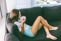 Teenage girl eating brekfast on couch in living room Royalty Free Stock Photo