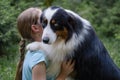 teenage girl embrace australian shepherd dog in summer. Stand in forest Royalty Free Stock Photo