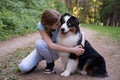 teenage girl embrace kiss australian shepherd dog in summer. Stand in forest Royalty Free Stock Photo