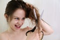 Teenage girl emotionally cuts scissors wet muddled hair