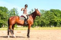 Teenage girl equestrian showing ok sign. Vibrant summertime outdoors