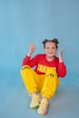 teenage girl in fashion stylish bright clothes. little lady in red and yellow on blue background. makeup and hairdo Royalty Free Stock Photo