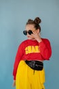 teenage girl in fashion stylish bright clothes. little lady in red and yellow on blue background. makeup and hairdo Royalty Free Stock Photo