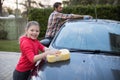 Teenage girl and father washing a car Royalty Free Stock Photo