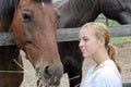 Teenage girl feeding horses in the farm Royalty Free Stock Photo