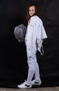 Teenage girl fencer dressed in uniform with epee and helmet