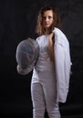 Teenage girl fencer dressed in uniform with epee and helmet