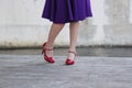 Teenage Girl in Purple Dress Displays Red High Heels on Dock