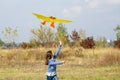 Teenage girl flying a yellow kite. Beautiful young girl kite fly. Happy little girl running with kite in hands on the beautiful Royalty Free Stock Photo