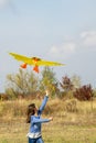 Teenage girl flying a yellow kite. Beautiful young girl kite fly. Happy little girl running with kite in hands on the beautiful Royalty Free Stock Photo