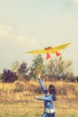 Teenage girl flying a yellow kite. Beautiful young girl kite fly. Happy little girl running with kite in hands on the
