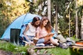 Teenage girl in front of tent camping in forest. Royalty Free Stock Photo