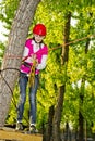 A teenage girl goes on hinged trail in extreme rope park Royalty Free Stock Photo