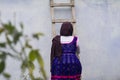 Teenage girl going up from wooden ladder