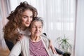 A teenage girl with grandmother at home, hugging. Royalty Free Stock Photo