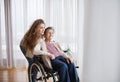 A teenage girl with grandmother at home, hugging. Royalty Free Stock Photo