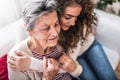 A teenage girl with grandmother at home, hugging. Royalty Free Stock Photo